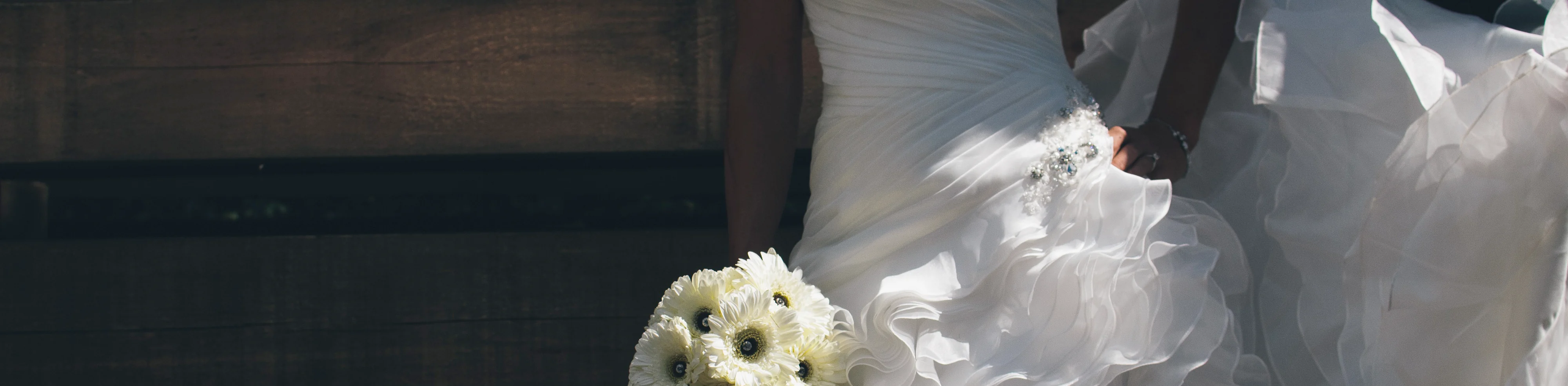 Bride in a ruffled white gown holding a bouquet