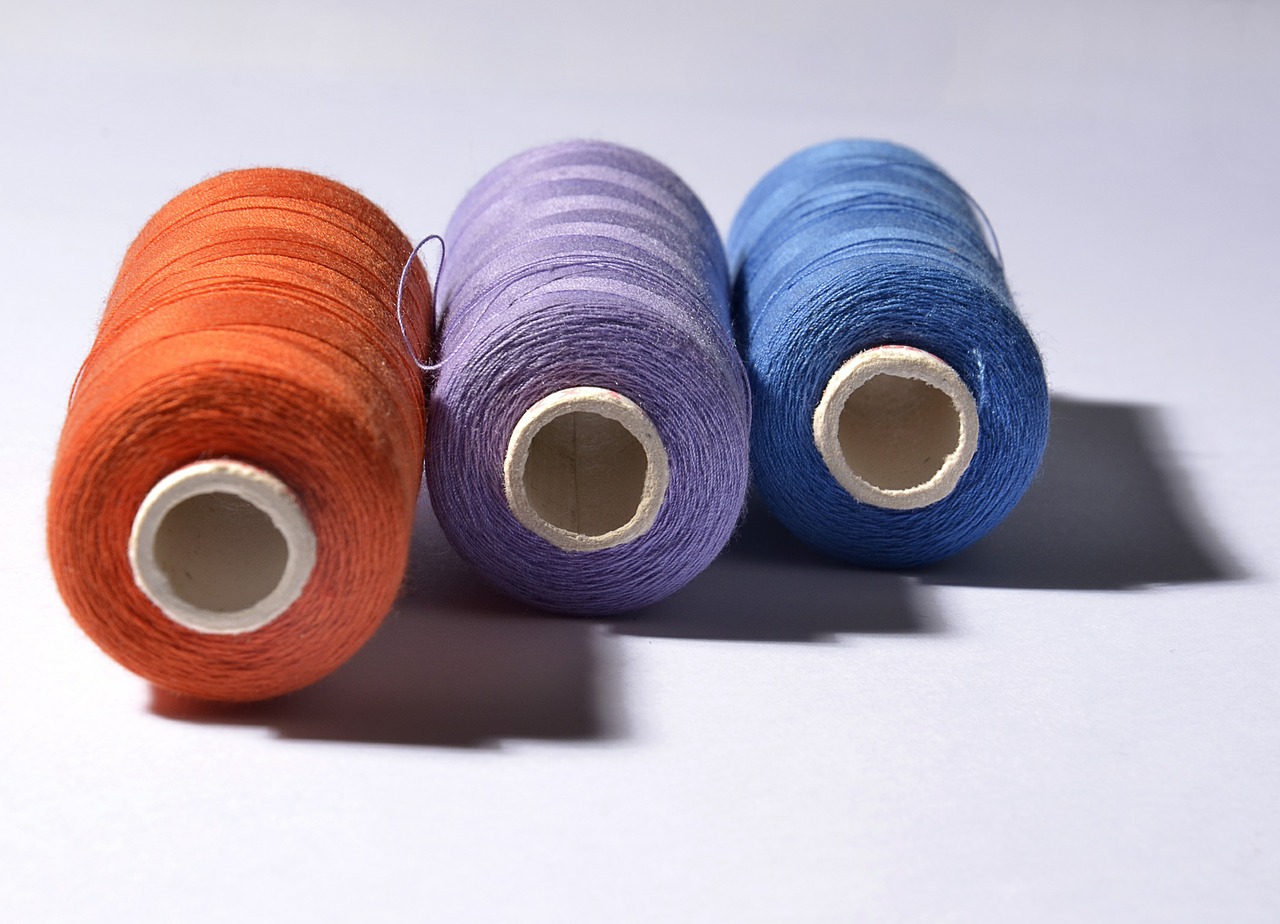 Spools of orange, purple and blue thread