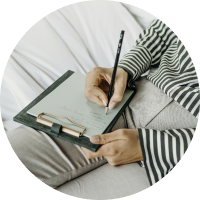 Hands writing in a journal