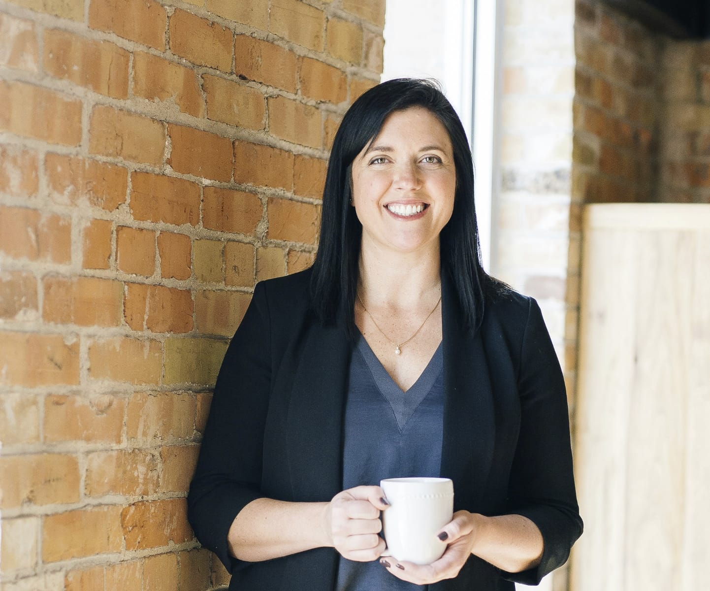 Life coach Christine Smith smiling and holding a coffee mug